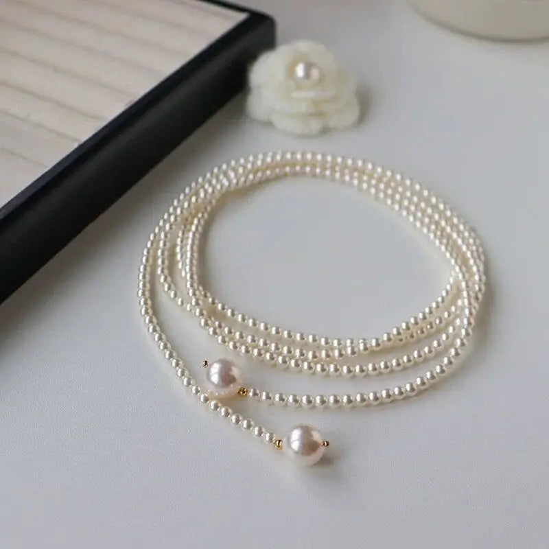 Este outono e inverno novo colar de corrente de suéter redondo, brilhante e quente branco Shijia pérola longa em camadas troude um charme feminino