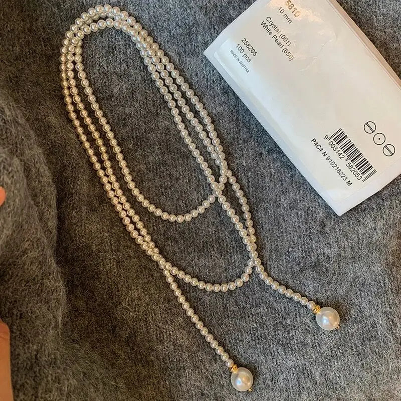 Este outono e inverno novo colar de corrente de suéter redondo, brilhante e quente branco Shijia pérola longa em camadas troude um charme feminino