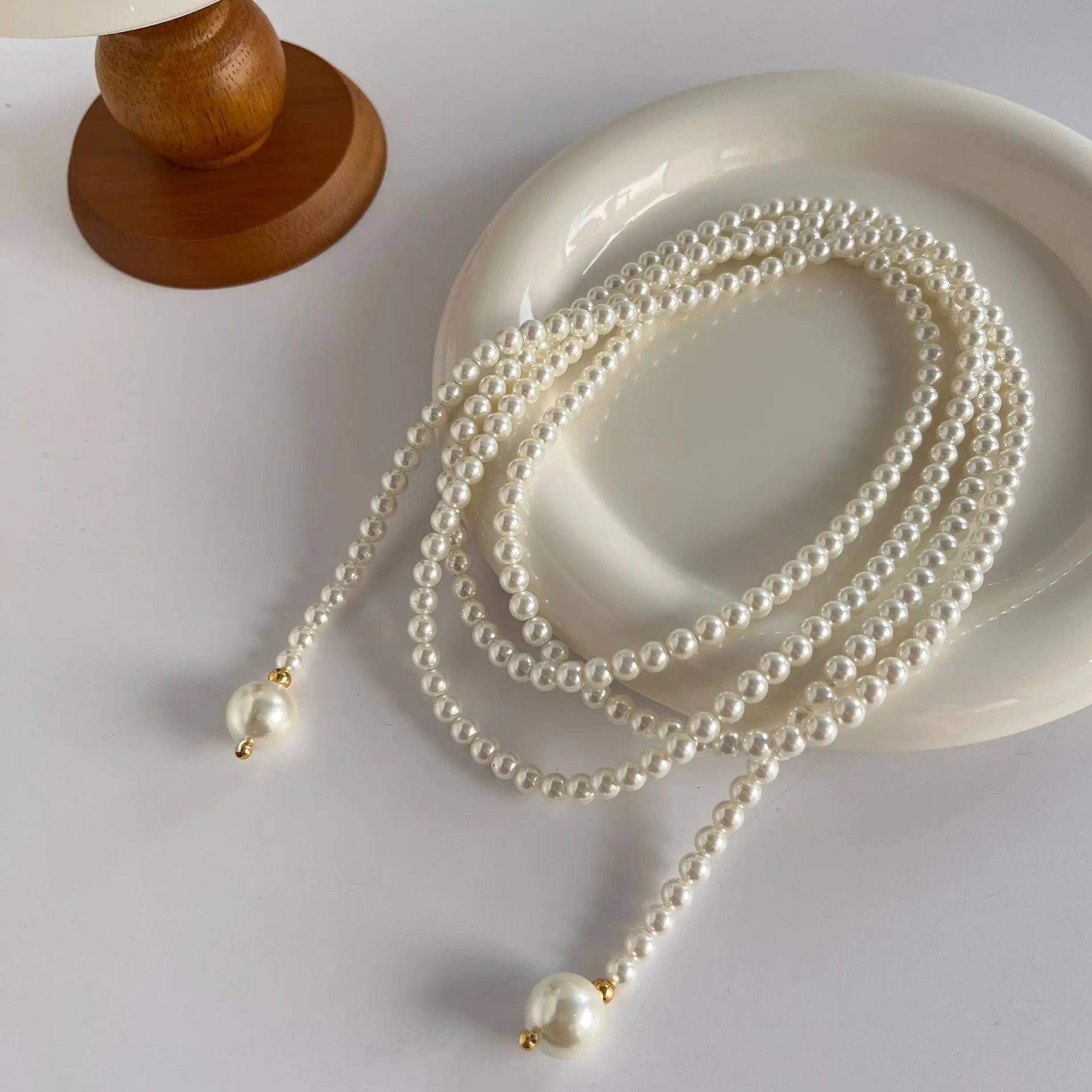 Este outono e inverno novo colar de corrente de suéter redondo, brilhante e quente branco Shijia pérola longa em camadas troude um charme feminino