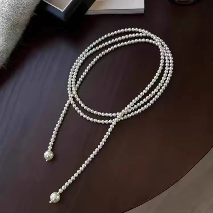 Este outono e inverno novo colar de corrente de suéter redondo, brilhante e quente branco Shijia pérola longa em camadas troude um charme feminino